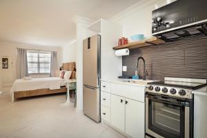 a kitchen with a stove top oven next to a bed at La Mer Suites in Fort Lauderdale