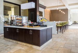 a kitchen with a counter and a bar with chairs at Hilton Garden Inn Raleigh Cary in Cary