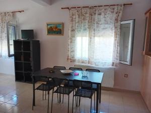 a dining room with a black table and chairs at Lampros apartments in Loutra Edipsou