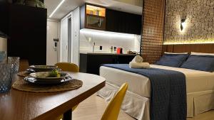 ein Schlafzimmer mit einem Bett und einem Tisch sowie ein Esszimmer in der Unterkunft Loft de Luxo no Bairro mais nobre de Goiânia in Goiânia