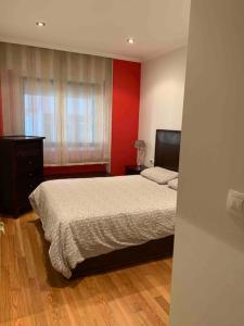 Un dormitorio con una cama y una pared roja. en Coastify Bueu, en Bueu