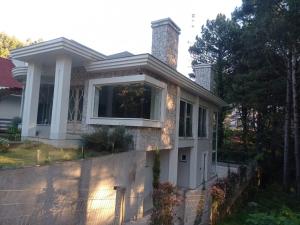 uma casa com uma casa de pedra com uma cerca em A VIDA É BELLA em Gramado