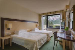 マルグラーテにあるHotel Griso Collectionのベッドが2つと窓があるホテルの部屋