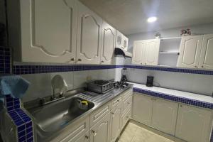 una cocina con armarios blancos y fregadero en Apartamento hermosa Vista al Mar en el Rodadero Santa Marta, en Santa Marta