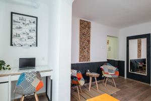 ein Wohnzimmer mit einem Schreibtisch und Stühlen in der Unterkunft NEW Iorga4 OldCity SelfCheckIn in Timişoara