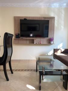 a living room with a tv and a glass table at Apartamento 2 habitaciones in Barranquilla