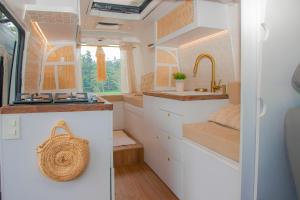 uma cozinha com armários brancos e um lavatório em Campervan Bogota Rolling Suite em Bogotá