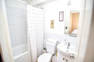 uma casa de banho branca com um WC e um lavatório em Cómodo departamento en Curicó em Curicó