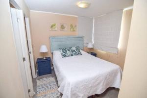 Cómodo departamento en Curicó في كوريكو: غرفة نوم صغيرة بها سرير ومصباحين
