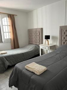 a bedroom with two beds and a table with a lamp at Complejo Lamadrid - semiprivado in Ciudad Lujan de Cuyo