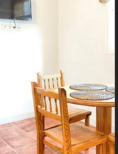 einen Holztisch mit einem Stuhl und einem Tisch mit einem TV in der Unterkunft Casa Veronica 5 , 1 Dormitorio in Arona