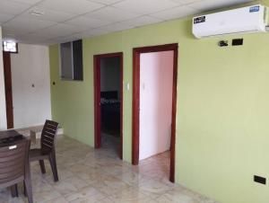 a room with green walls and a hallway with a door at Kiara's house in Puerto Baquerizo Moreno