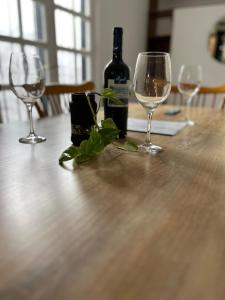 een tafel met twee wijnglazen en een fles wijn bij Complejo Lamadrid - semiprivado in Ciudad Lujan de Cuyo