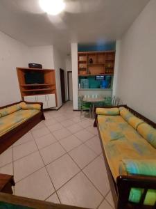 a living room with two couches and a table in it at Apart-hotel Marinas do Canal in Cabo Frio
