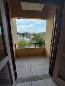 a room with a balcony with a view of the water at Apart-hotel Marinas do Canal in Cabo Frio