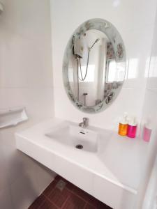 W białej łazience znajduje się umywalka i lustro. w obiekcie KS HOUSE w mieście Bangkok