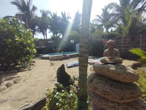 una estatua sentada sobre una pila de rocas en Laguna Hotel Máncora - Beach & Pool, en Máncora