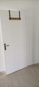 a white door with a metal handle in a room at Jolie maison entre Terre et Mer in Lithaire