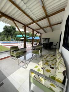 a patio with several chairs and a table and a bed at Finca Venecia de Techo Azul en la tebaida in La Tebaida