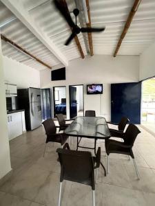 una sala da pranzo con ventilatore a soffitto, tavolo e sedie di Finca Venecia de Techo Azul en la tebaida a La Tebaida