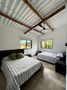 a bedroom with two beds and two windows at Finca Venecia de Techo Azul en la tebaida in La Tebaida