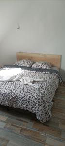1 cama con edredón y almohadas en blanco y negro en Jolie maison entre Terre et Mer, en Lithaire
