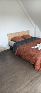 een slaapkamer met een bed en een houten vloer bij Jolie maison entre Terre et Mer in Lithaire