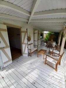 una veranda con sedie e tavolo su una casa di Bungalow Vanille a Sainte-Anne