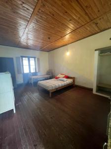 1 dormitorio con cama y techo de madera en Estancia Santa Rita en Punta Indio