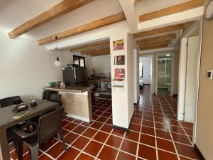 cocina y comedor con suelo de baldosa roja en Cabaña Hostal Santorini, en Colón