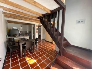 Habitación con escalera, mesa y sillas en Cabaña Hostal Santorini, en Colón