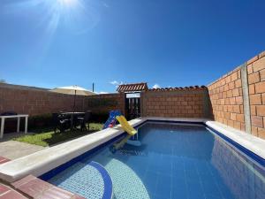 una piscina con un tobogán en un patio trasero en Cabaña Hostal Santorini, en Colón