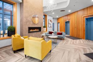 a lobby with yellow chairs and a fireplace at Alpenglow Lodge by MVA in Whistler