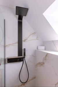 a shower in a white bathroom with a black object at Moderne studio in Nieuwpoort