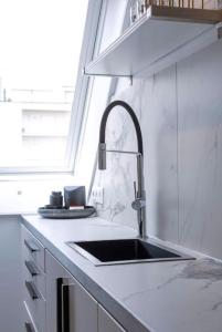 a white kitchen with a sink and a window at Moderne studio in Nieuwpoort