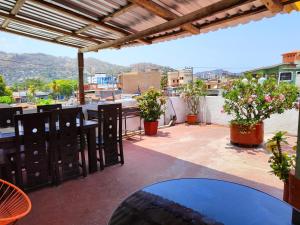 a patio with tables and potted plants on a roof at Hotel Victoria in Zihuatanejo