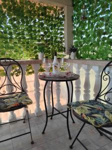 a table with two wine glasses and two chairs at Apartmani Jozić in Garešnica