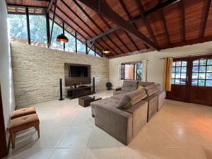 uma grande sala de estar com um sofá e uma televisão em Mega Casa em sítio churrasco piscina em Ipiabas RJ em Barra do Piraí
