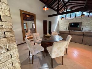 uma sala de jantar com uma mesa de vidro e cadeiras em Mega Casa em sítio churrasco piscina em Ipiabas RJ em Barra do Piraí