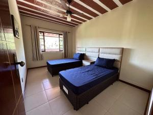 1 dormitorio con 2 camas y ventana en Mega Casa em sítio churrasco piscina em Ipiabas RJ, en Barra do Piraí