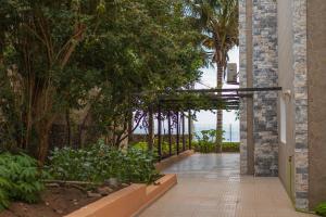 une passerelle dans un bâtiment avec des arbres et des plantes dans l'établissement Cidade Paradise Guesthouse, à Cidade Velha