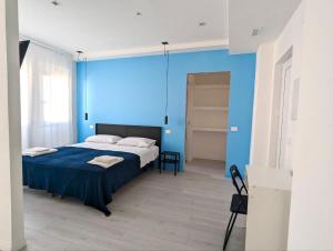 niebieska sypialnia z łóżkiem i niebieską ścianą w obiekcie MiPA w mieście Milazzo
