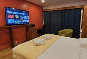 a hotel room with a bed and a flat screen tv at SAS CLP - La Marina in Kourou