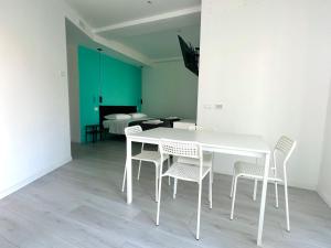 a white table and chairs in a room with a bedroom at MiPA in Milazzo