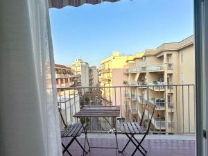 balkon ze stołem, krzesłami i budynkami w obiekcie MiPA w mieście Milazzo