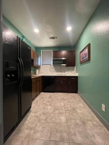 eine Küche mit grünen Wänden und einem schwarzen Kühlschrank in der Unterkunft Fresno Vacation Rental 106 in Fresno