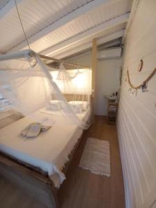 una camera con un letto a baldacchino bianco di Bungalow Vanille a Sainte-Anne