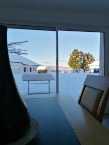 Habitación con mesa y ventana grande de cristal. en Gîte entre mer et montagne, en Saint-Vincent
