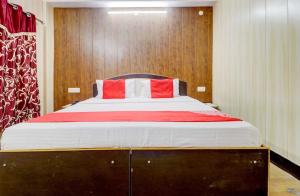 a bedroom with a large bed with red and white pillows at Hotel Shimla View in Jutogh