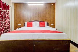 a bedroom with a large bed with red and white pillows at Hotel Shimla View in Jutogh
